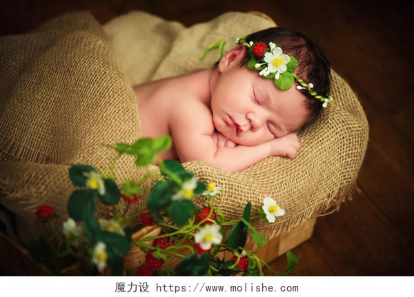 棉麻背景上熟睡的新生草莓婴儿